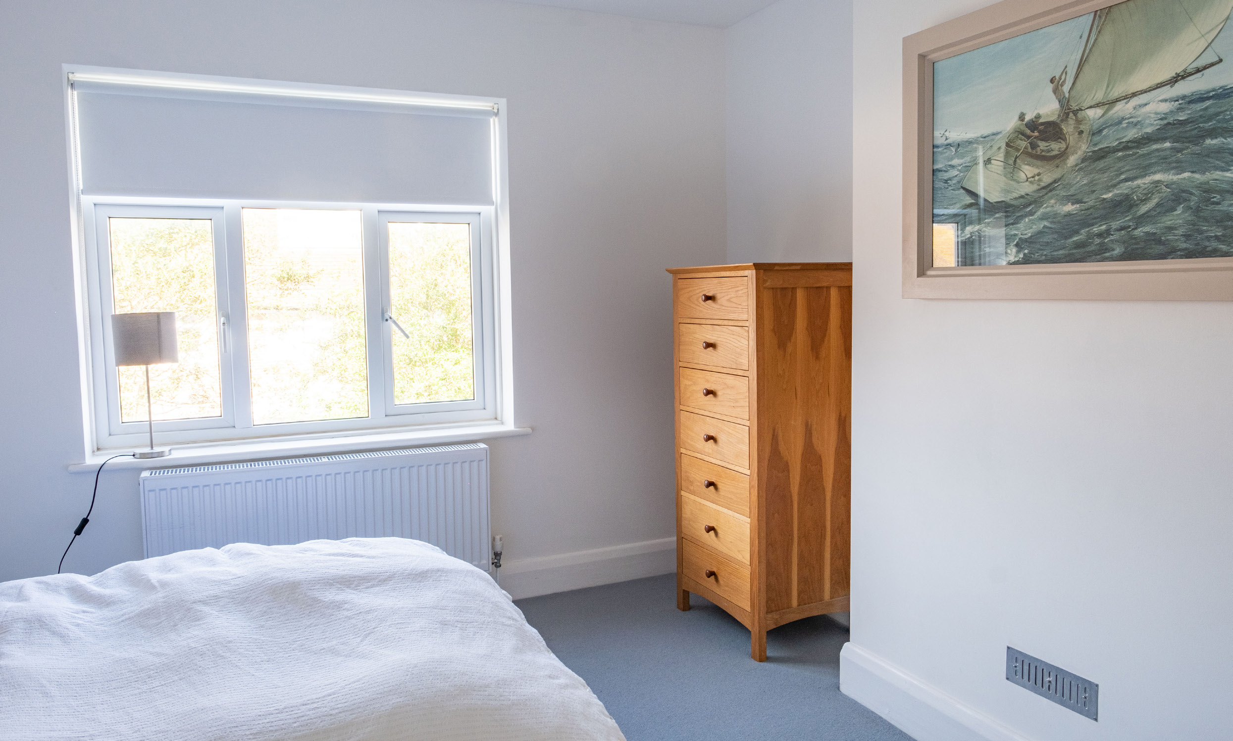 Calm second double bedroom with natural wood furniture